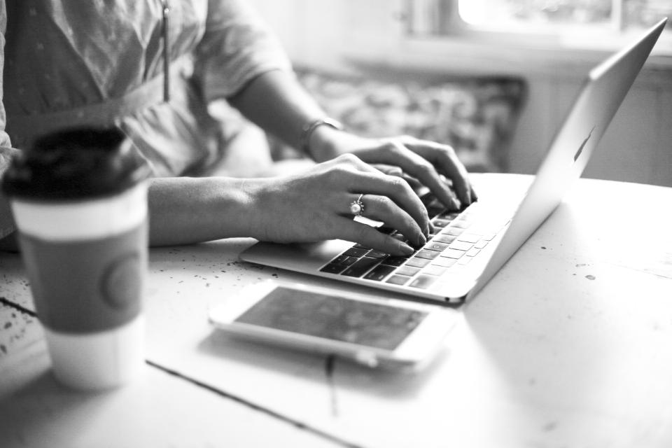Hands typing on a laptop to pay rent online